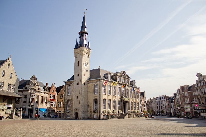 De Grote Markt van Lier met het stadhuis en het belfort onder een blauwe lucht.